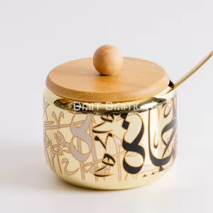 Golden Arabic calligraphy sugar jar with bamboo lid and gold spoon — elegant Arabic-style serving container from Bait Baitk.