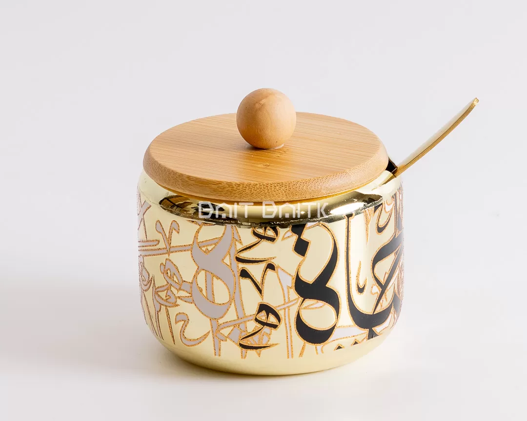 Golden Arabic calligraphy sugar jar with bamboo lid and gold spoon — elegant Arabic-style serving container from Bait Baitk.