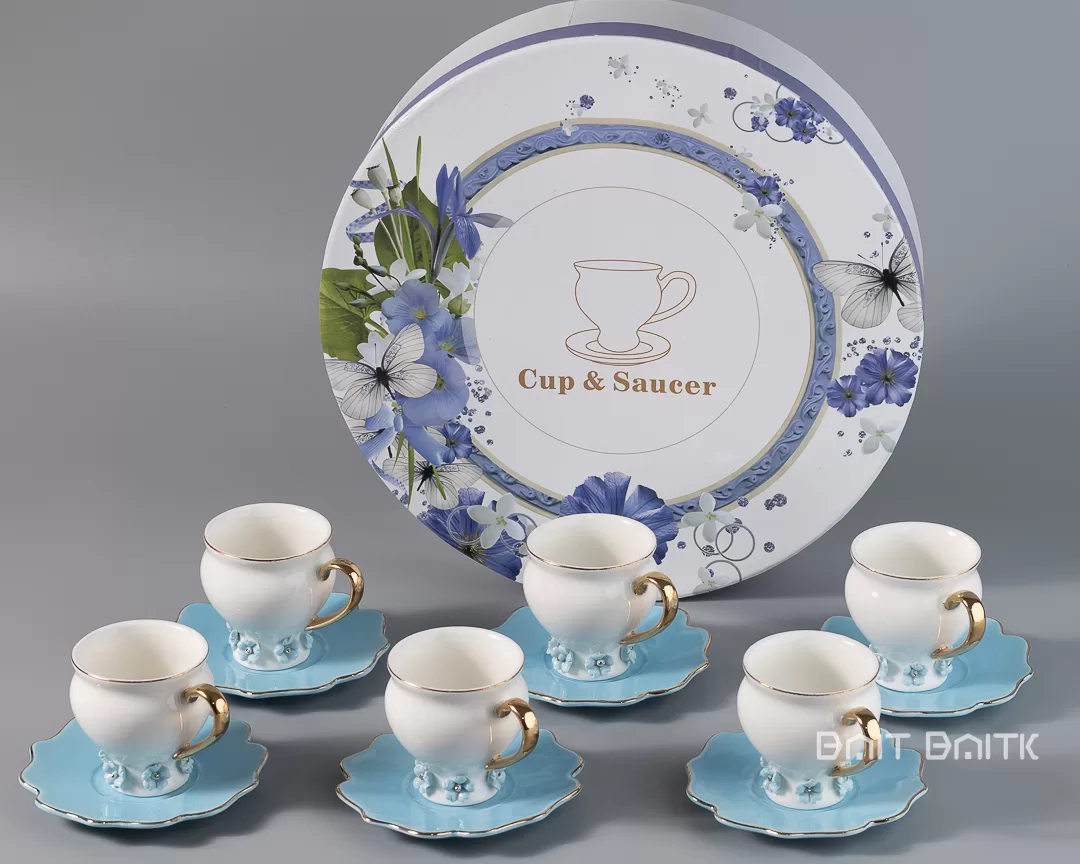 Blue coffee cup and saucer set of six in front of round floral gift box