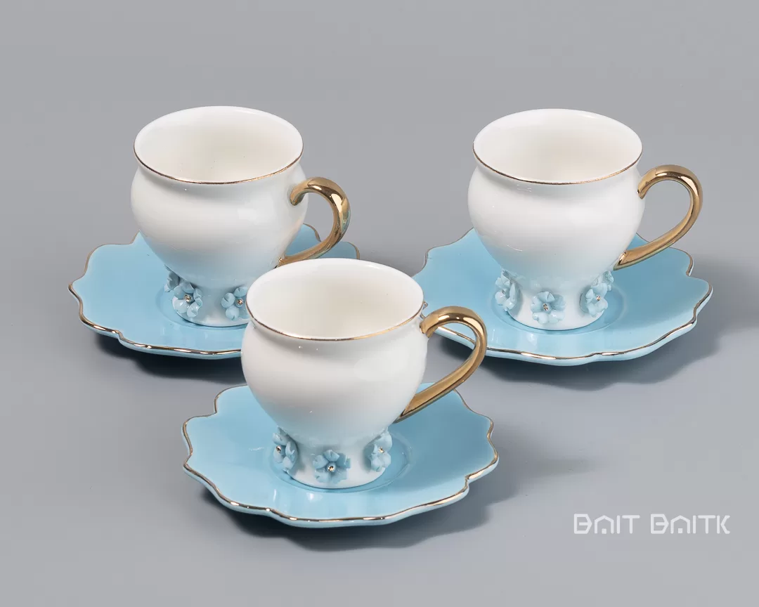 Close view of three blue coffee cups with saucers and gold handles