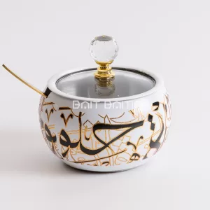 "White Arabic calligraphy sugar jar with gold accents, crystal knob, and gold spoon — elegant modern jar from Bait Baitk."